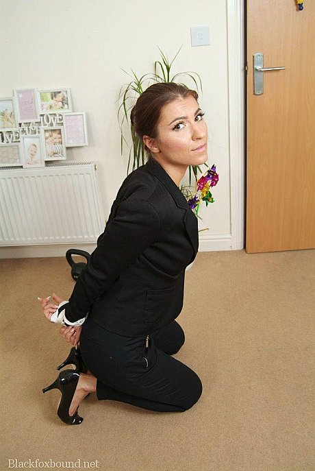 Fully clothed British secretary is tied up with rope in reception area