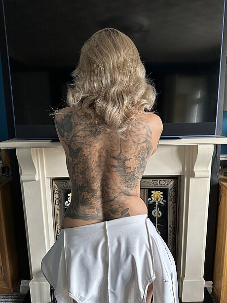 Tattooed yellow-haired Inked MILF releases her huge titties from a latex bodystocking