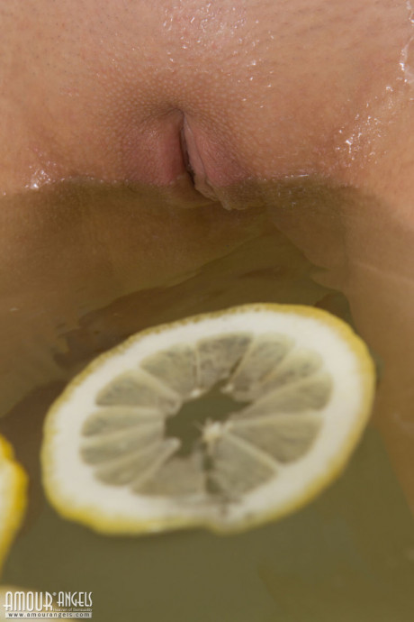 Pretty blondy teenie sinks her bald twat into a tub filled with lemon slices - #81970
