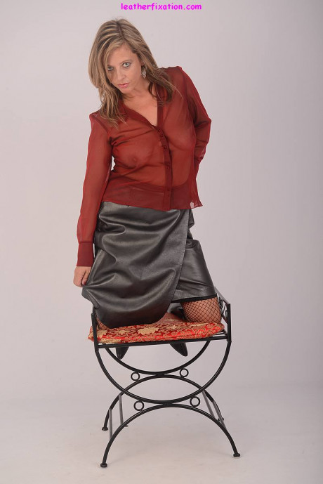 Clothed chick broad Louise models in leather skirt and boots paired with fishnets