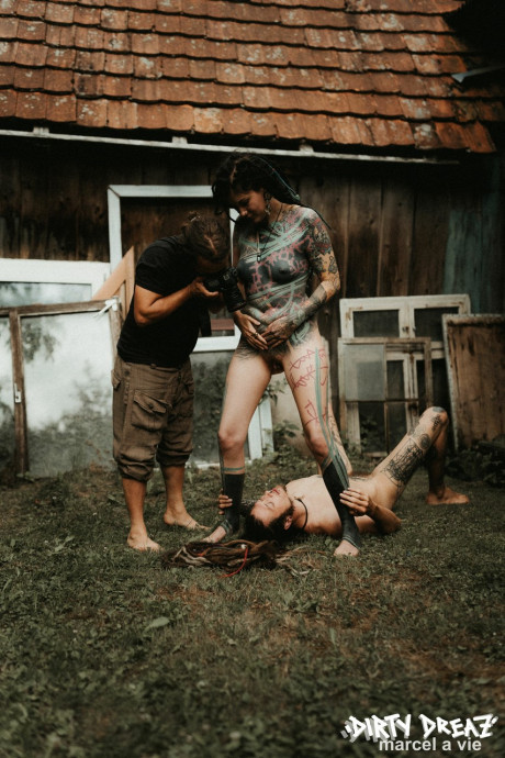 Heavily tattooed skanks piss on a naked boy boy stud outside the back steps of a house - #846998