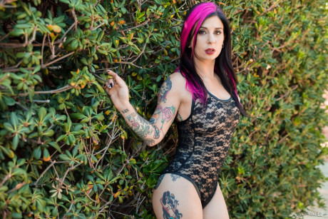Tattooed solo model Joanna Angel getting undressed in front of bushes outside - #873400