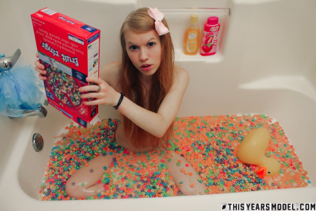 Young young looking chick girl girl Dolly Little empties a box of cereal into her bathwater - #129288