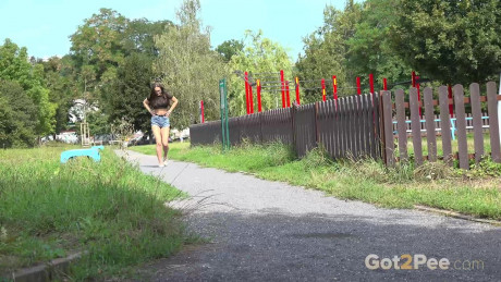 Brunette girl lady Barbe pulls down her shorts to pee while on a walking path - #430291