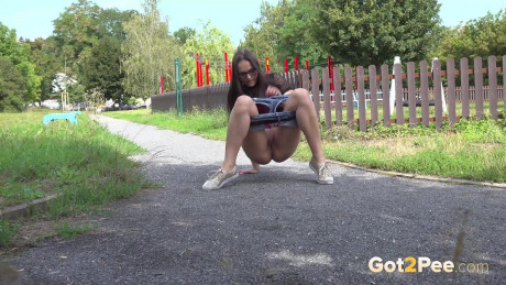 Brunette girl lady Barbe pulls down her shorts to pee while on a walking path - #430294