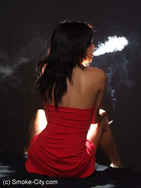 Young teenie brunette shows her sleek legs while smoking in a red dress - #187327