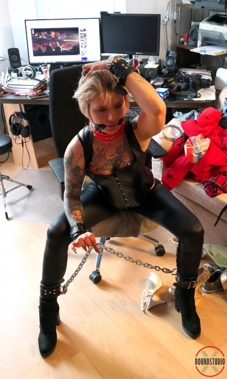 Blond girl gf lady Roxxxi Manson struggles against a gag while chained in leather wear - #500082