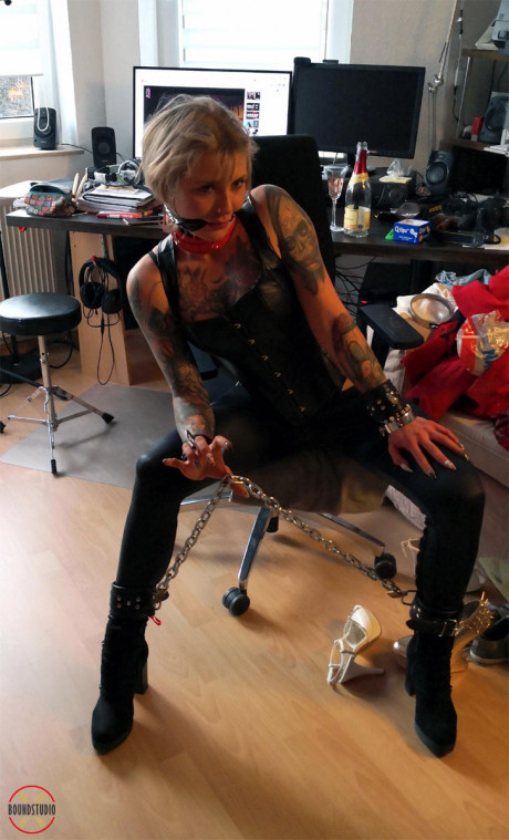 Blond girl gf lady Roxxxi Manson struggles against a gag while chained in leather wear - #500083