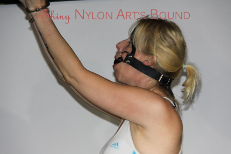 Pretty Pia tied and gagged overhead with chains, cuffs and a holster with a