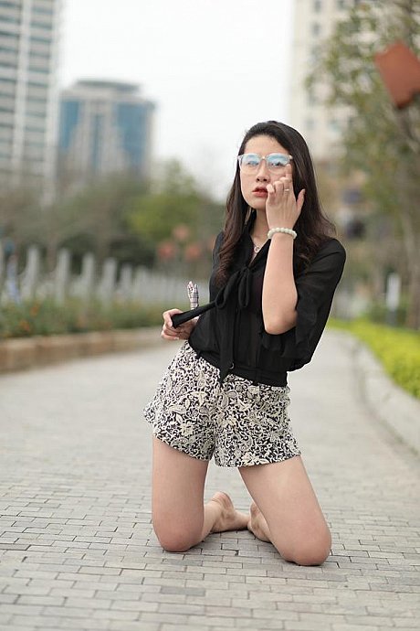 Barefoot oriental babe flaunts her pretty legs outdoors wearing a miniskirt