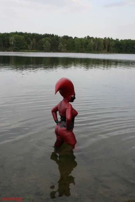 Fetish model Avengelique wades into a body of water in a rubber costume - #305529
