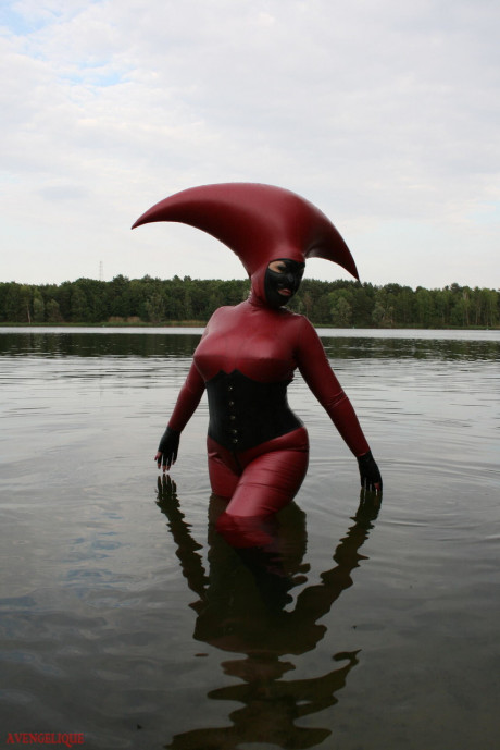 Fetish model Avengelique wades into a body of water in a rubber costume - #305534