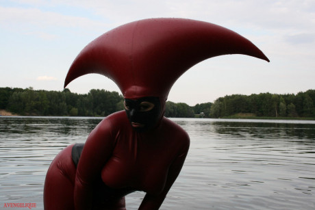 Fetish model Avengelique wades into a body of water in a rubber costume - #305535