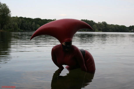 Fetish model Avengelique wades into a body of water in a rubber costume - #305536