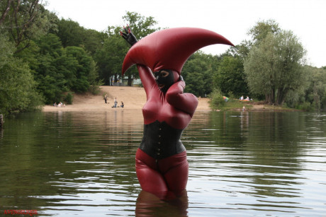 Fetish model Avengelique wades into a body of water in a rubber costume - #305538