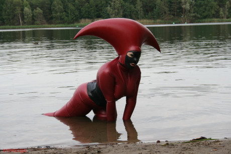 Fetish model Avengelique wades into a body of water in a rubber costume - #305540