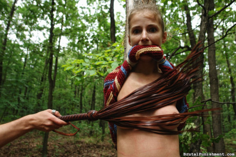 Thin blondy bitch girlfriend woman is flogged while tied to a tree in the forest - #291371